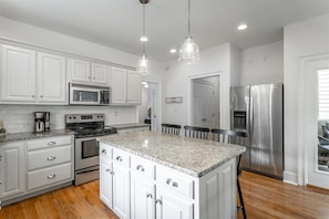 A kitchen with white cabinetry, granite countertops, stainless steel appliances, and pendant lighting. - Oliver's Landing | Walk Right to North Shore! (Chattanooga)