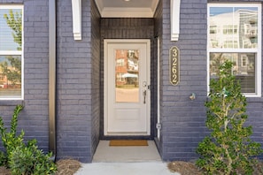 A residential building with a white front door, a mailbox, and a small tree in the entrance. - Near Downtown & Lookout Mtn | Game Room | Designer (Chattanooga)