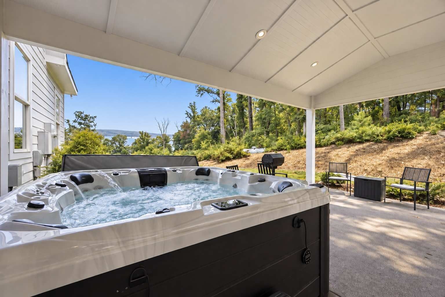 Un jacuzzi con vistas a una casa y árboles.