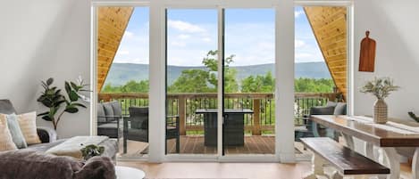 A spacious living area with a large sliding glass door leading to an outdoor deck.