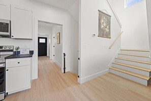 A modern kitchen with white cabinetry and a built-in oven. - Cottonwood Crest | Epic Family Retreat • Hot Tub! (Rossville)