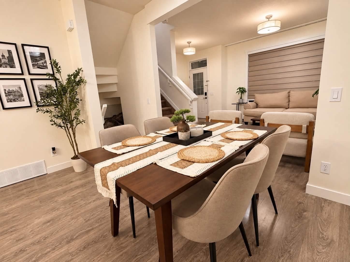 Un espace repas avec une longue table, des chaises et un escalier en arrière-plan.