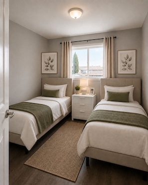 A bedroom with two beds, a bedside table with a lamp, a window with curtains, and framed artwork on the wall. - Family-Friendly 5BR Home| Basement Included (Edmonton)