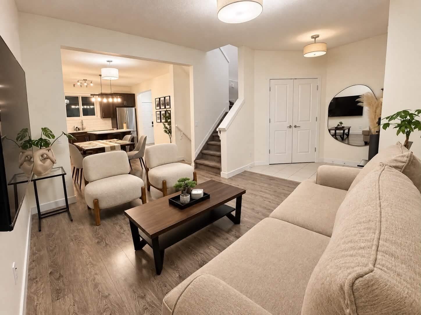 A modern living room with a sofa, a coffee table, and a dining area with chairs.