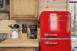 A red Frigidaire refrigerator with a digital coffee maker and a toaster on a wooden countertop. - Cedarbrook Treehouse | Rustic Escape • Hot Tub! (Trenton)