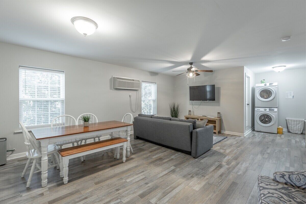 Ein modernes Wohnzimmer mit Esstisch, Sofa und Deckenventilator.