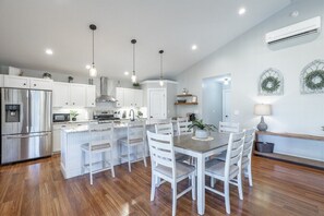 A modern kitchen with white cabinetry, a central island, and pendant lighting. - 2 Apartments with Country Views | Dog Friendly! (Rossville)