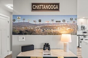 Eine an der Wand befestigte Schilder mit dem Schriftzug „Chattanooga“ über einem Stadtbild-Mural mit beschrifteten Sehenswürdigkeiten.