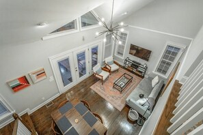 A spacious living area with a dining table, sofas, and a chandelier. - Stellar View | North Shore Retreat | 30+ Nights (Chattanooga)