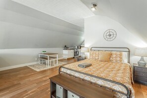 A bedroom with a bed, bedside table, lamp, and a small desk with a chair. - Barndominium | Views of Lookout Mtn | NEW Hot Tub! (Rossville)
