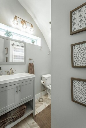 A bathroom with a vanity, a toilet, and framed wall art. - Barndominium | Views of Lookout Mtn | NEW Hot Tub! (Rossville)
