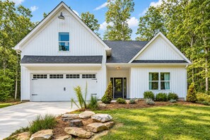 A two-story white house with a garage, a front porch, and a well-maintained lawn. - Cloudland Summit | Hot Tub + Grill | Dog Friendly (Rising Fawn)