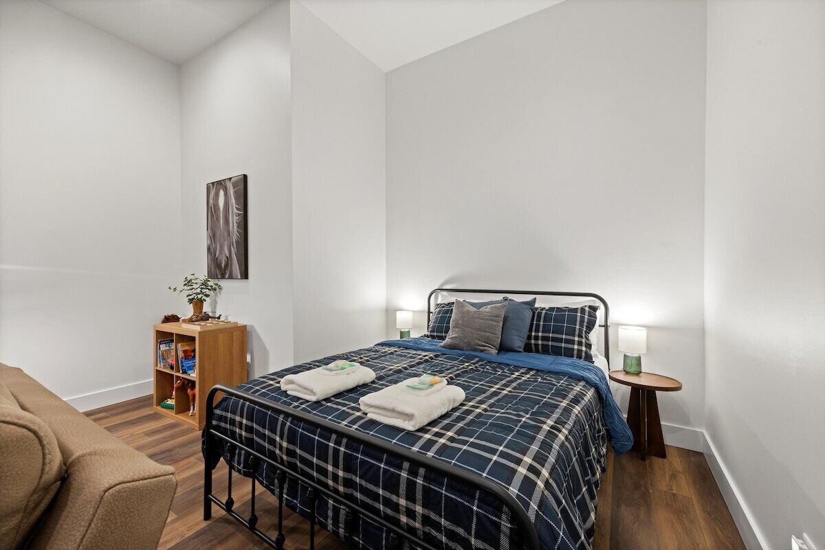 Ein Schlafzimmer mit einem Bett, Nachttischen, einem Bücherregal und einem Bild an der Wand.
