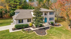 A two-story house with a well-maintained lawn and a small garden area. - Lake Hills Landing | Family Friendly+Hot Tub+EV (Trenton)