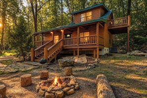 A cabin with a deck, a fire pit, and a staircase leading to an upper level. - Hideaway Lodge | 2BR Nature Retreat | Hot Tub! (Trenton)