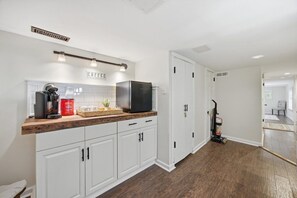 A kitchen with white cabinets, a wooden countertop, and a coffee station. - The Nest: Epic Family Home w/ Rock Climbing+Slide (Chattanooga)
