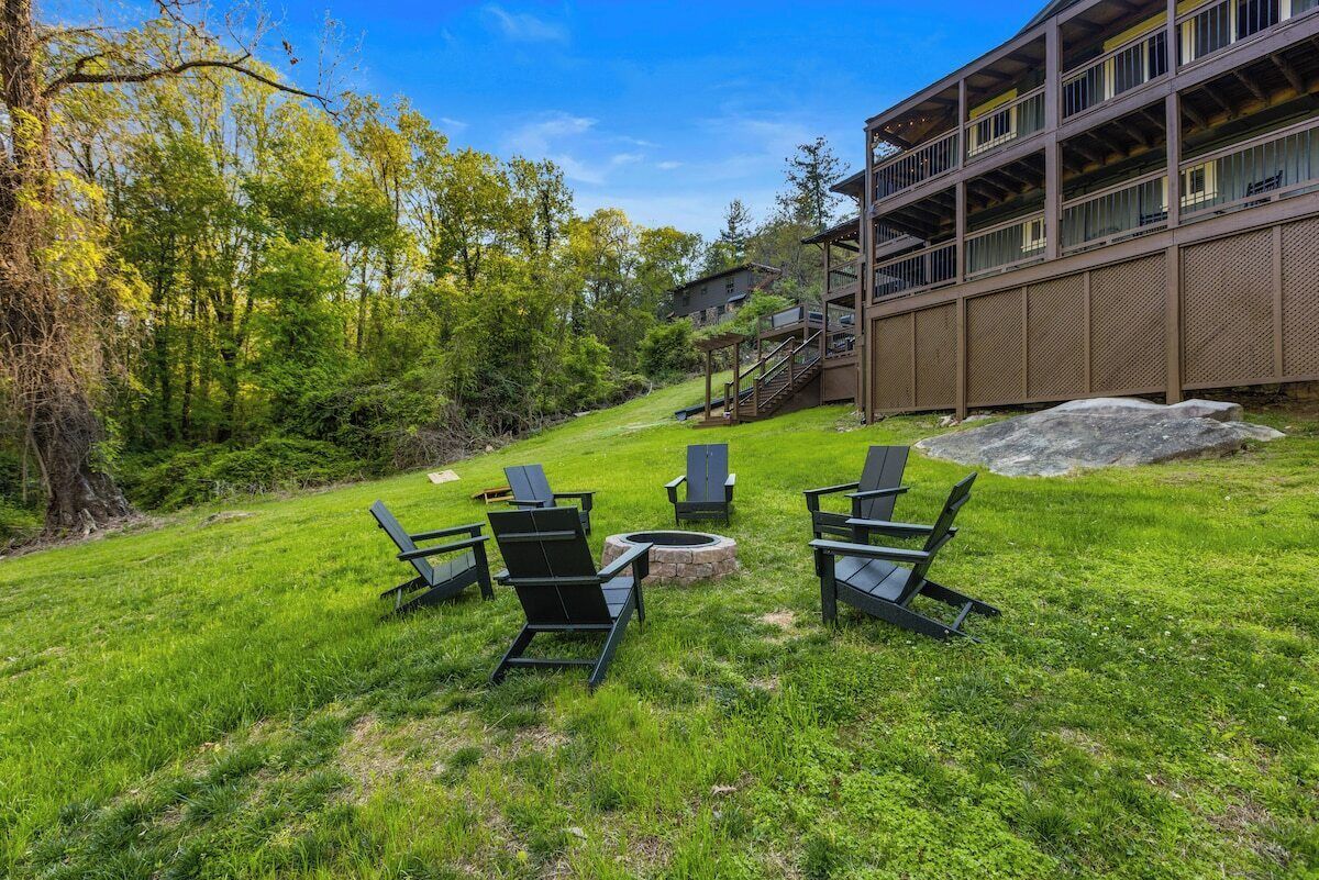A grassy outdoor area with outdoor seating and a building with multiple floors.