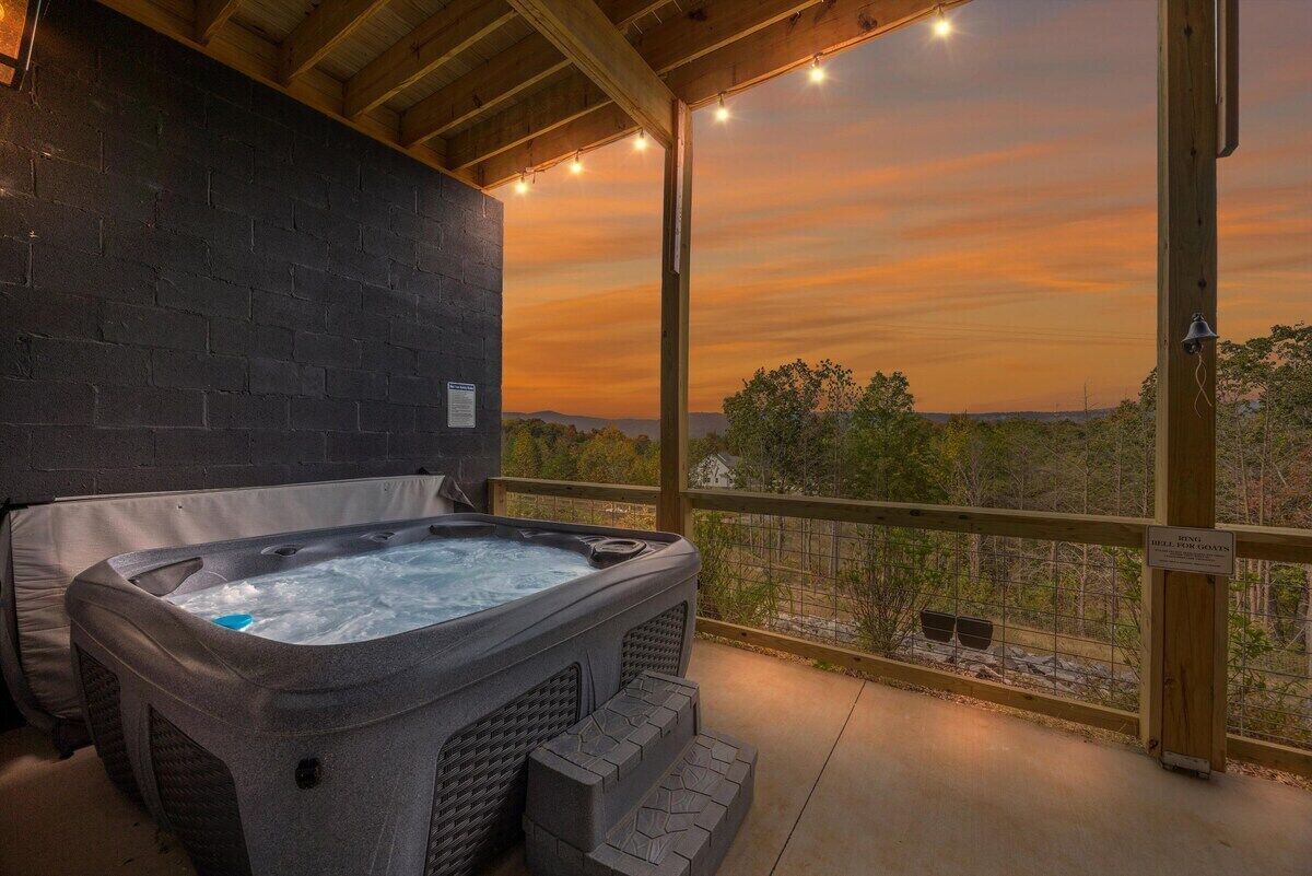 A hot tub on a balcony with a sunset view.