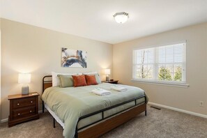 Bedroom 1 with a king bed and bedside lamps - The Wrenley Chateau | Great Location + Backyard! (Ringgold)