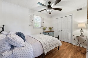 A bedroom with a bed, a dresser, a nightstand, a ceiling fan, a window with blinds, and a door. - Lake front/Hot Tub/Game Room/Dock  Home in Lexington, NC (Lexington)