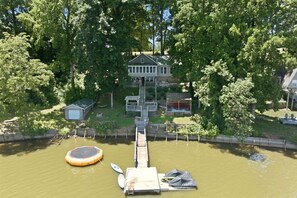A house with a dock extending into a body of water, surrounded by trees. - Lake front/Hot Tub/Game Room/Dock  Home in Lexington, NC (Lexington)