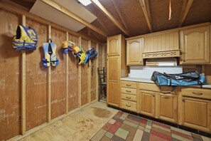 A kitchen with wooden cabinets, a tiled backsplash, and a rug on the floor. - Lake front/Hot Tub/Game Room/Dock  Home in Lexington, NC (Lexington)
