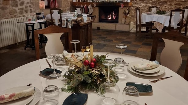 Un coin repas agrémenté d’un mur en pierre, d’une cheminée et d’une tête de cerf décorative.