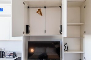 A modern kitchen with a built-in oven, a coffee machine, and a hanging rack for utensils. - Modern Studio with Pool, Gym, and Private Grill—Palermo (Buenos Aires)