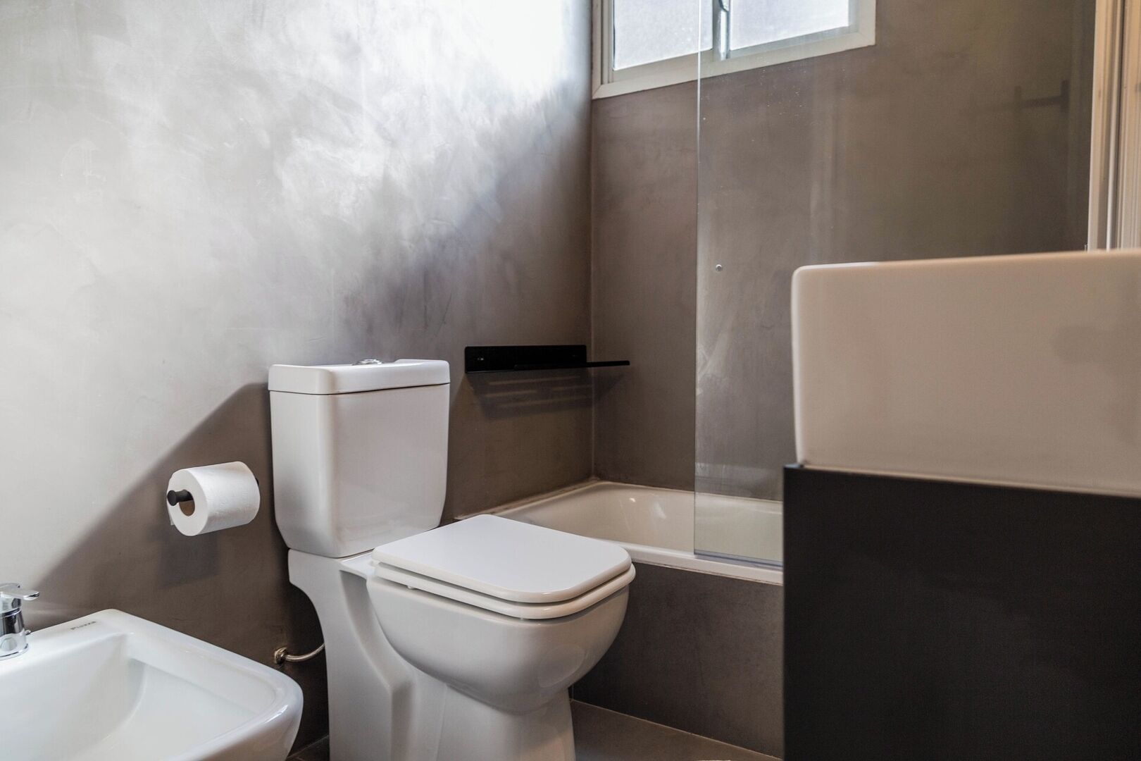 Une salle de bain avec des toilettes, un lavabo et une baignoire.