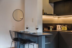 Eine moderne Küche mit Barbereich, ausgestattet mit Kaffeemaschine, Toaster und Wasserkocher.