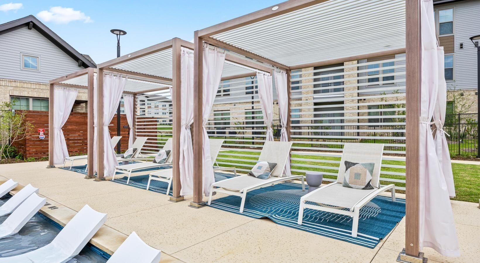 A poolside area with sun loungers and a covered seating area.
