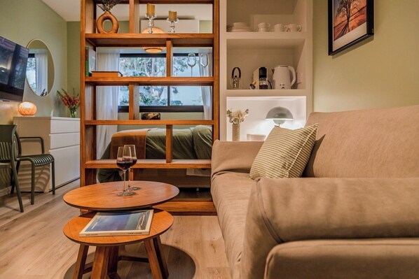 Uma sala de estar aconchegante com um sofá, uma mesa de centro e uma estante de livros.