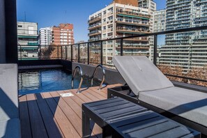Uma área de piscina no terraço com espreguiçadeiras e piscina.