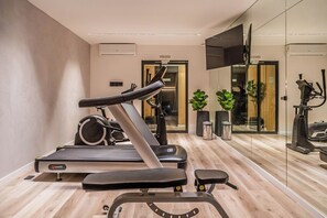 A modern gym with a treadmill, stationary bike, and exercise equipment. - Premium Studio | Pool, Gym, and Coworking Space (Buenos Aires)