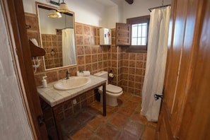 A bathroom with a sink, toilet, and a mirror. - Casas de Cantoblaco (Benamargosa)