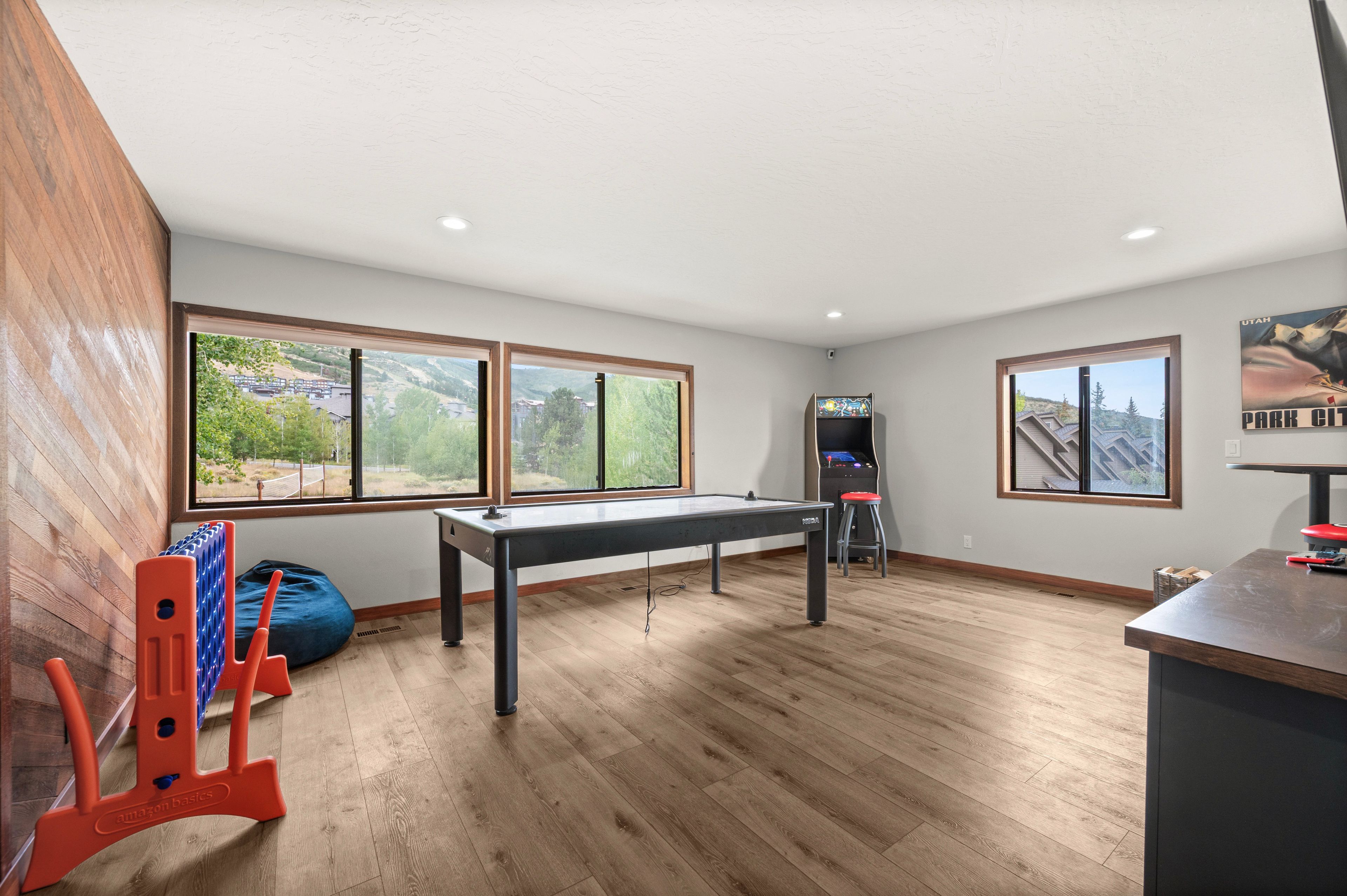 Una habitación con mesa de billar, ventanas con vistas a montañas y una mesa de fútbol.
