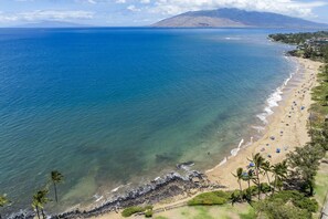 A coastal beach with clear waters, a sandy shore, and a mountainous backdrop. - Kihei Alii Kai B-302 - Ocean Views, Stunning Renovation, King Size Bed, Split AC (Kihei)