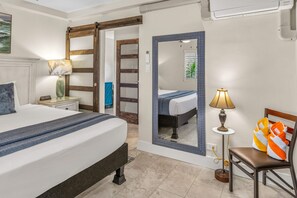Ein Hotelzimmer mit Bett, Nachttisch, Lampe, Stuhl und Spiegel.