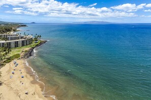 Ein Hotel an der Küste mit Strand, Meerblick und blauem Himmel.