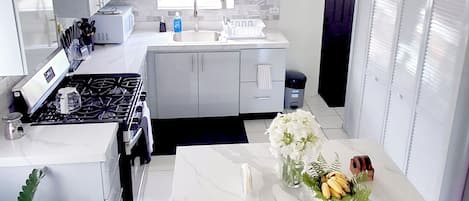 A modern kitchen with a central island, a stove, and a sink.