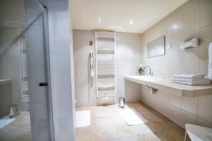 A modern bathroom with a glass shower enclosure, a white sink with a mirror, and a towel rack. - Gollner (Lebring-Sankt Margarethen)