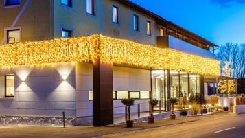 Ein Hotel mit zeitgemäßiger Fassade, großen Fenstern und einem gut beleuchteten Eingang.