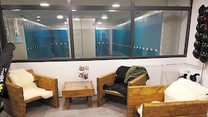 Una habitación con muebles de madera, un espejo y vista a un pasillo azul.