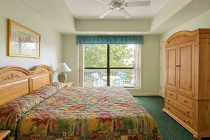 A bedroom with a bed, a wooden wardrobe, a window with a view, and a ceiling fan. - Egret Point HH-3 Bed/3 bath Condo- FREE golf for foursome daily; Full kitchen (Hilton Head Island)
