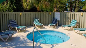 Une piscine avec des chaises longues et une clôture en bois.