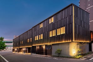 Ein modernes Gebäude mit einer glatten Fassade, großen Fenstern und einem gut beleuchteten Eingang.