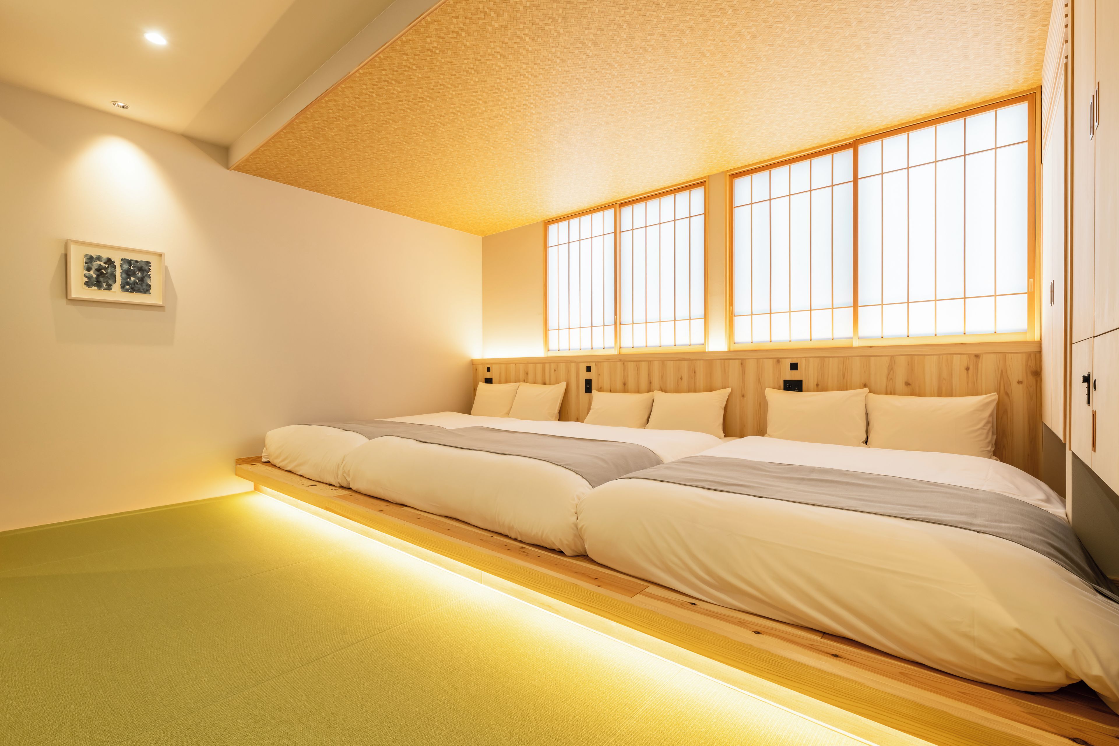 Una habitación con una cama grande, cabecero de madera y una ventana con diseño de cuadrícula.