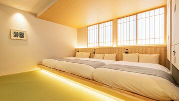 Una habitación con una cama grande, cabecero de madera y una ventana con diseño de cuadrícula.