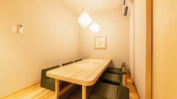 A dining area with a wooden table and green upholstered chairs.