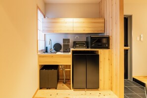 A compact kitchen with a built-in microwave, toaster, and dishwasher, featuring wooden cabinetry and a small sink. - Tsurezure-Ann Hakatagawa (Shimogofukumachi Hakata-ku, Fukuoka-shi)